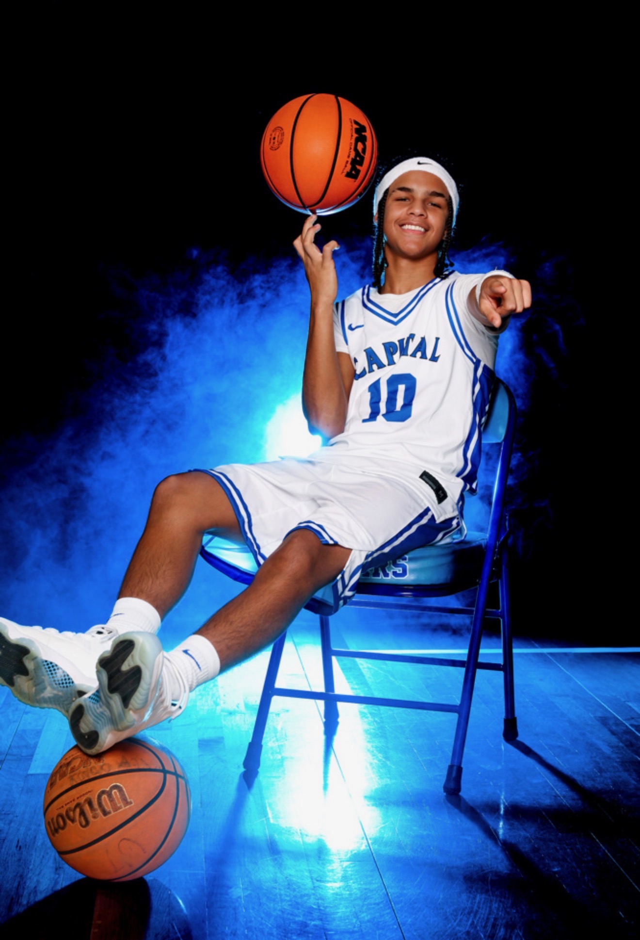 Kahsi Morgan seated in basketball uniform holding a basketball