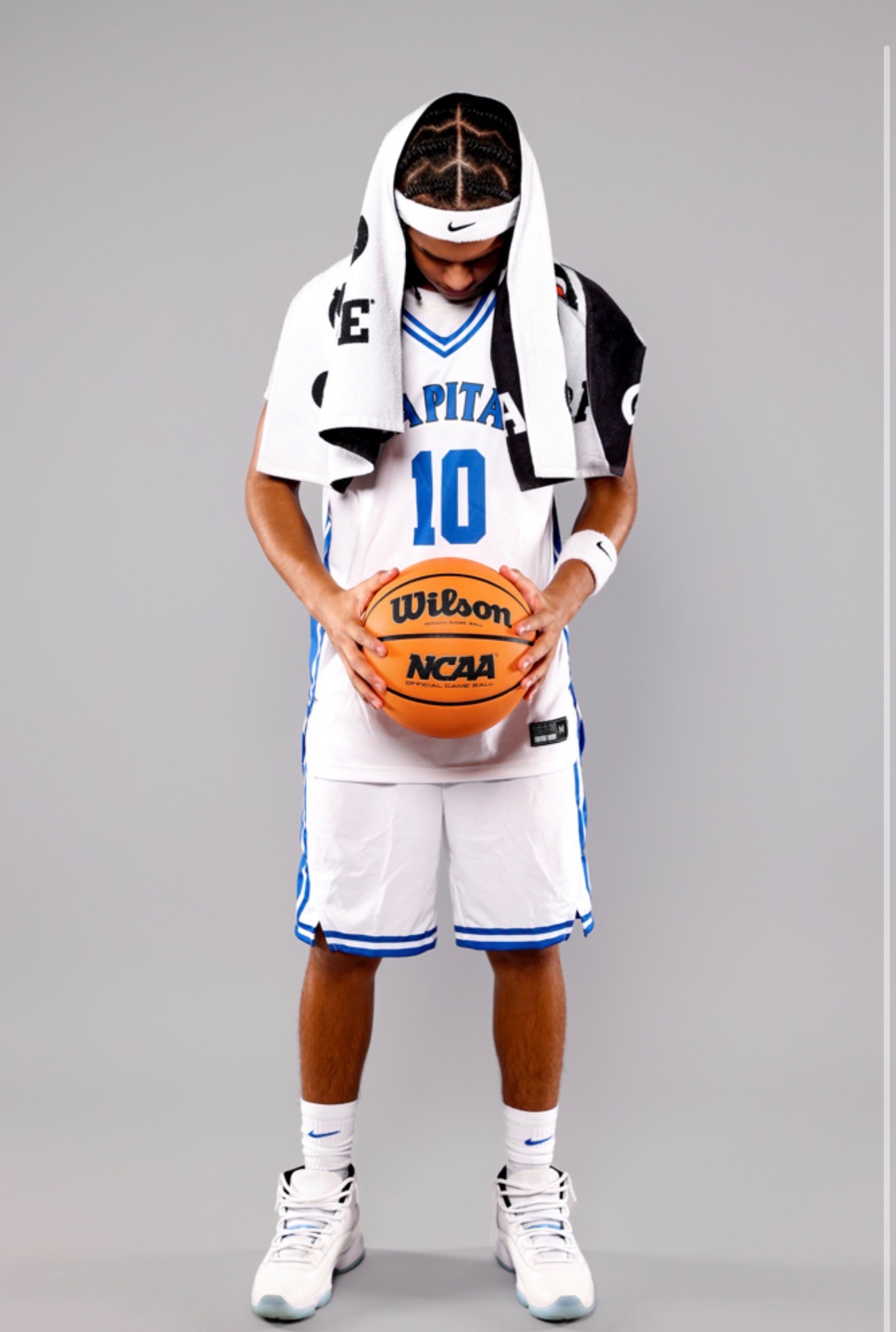 Kahsi Morgan holding a basketball with towel over shoulders